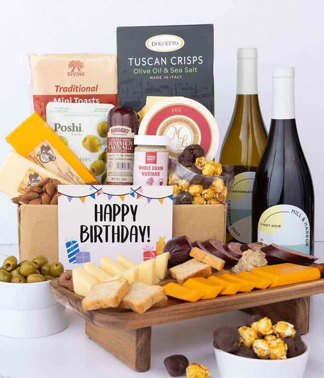 An abundant gift box filled with two bottles of California wine - red &amp; white, assorted crackers, three cheeses, summer sausage, snacks, and birthday card to make an amazing birthday spread.