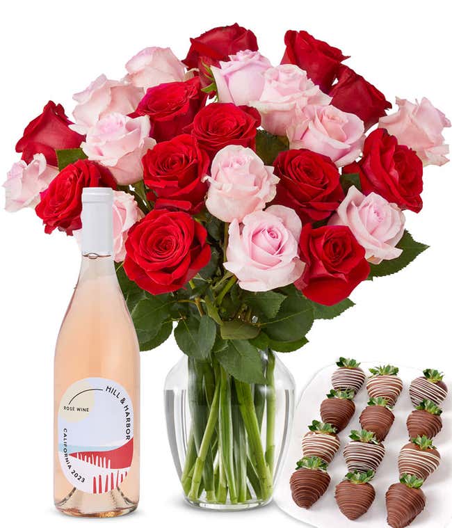 A mixed bouquet of 2 dozen red and blush roses in a clear vase is paired with a bottle of Hill &amp; Harbor Ros&eacute; and 12 chocolate-covered strawberries.