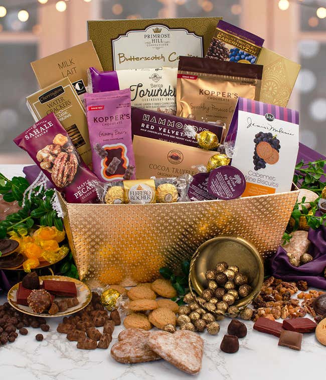 Gourmet chocolate and sweets gift basket with assorted truffles, cookies, chocolate-covered nuts, pecans, gummy bears, cocoa truffles, Ferrero Rocher, butterscotch candies, and wine biscuits displayed in a decorative gold container.