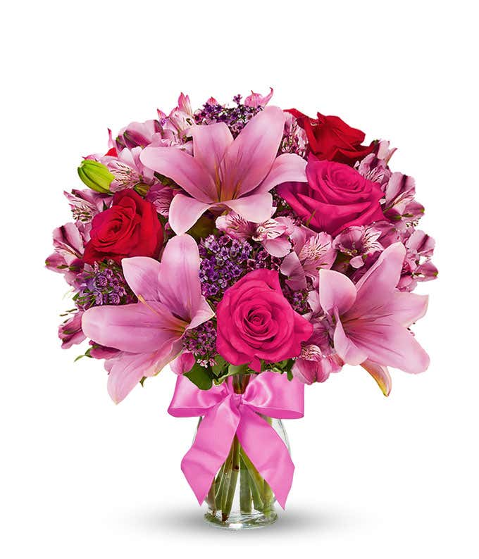 Red roses, pink lilies and pink alstroemeria and glass vase