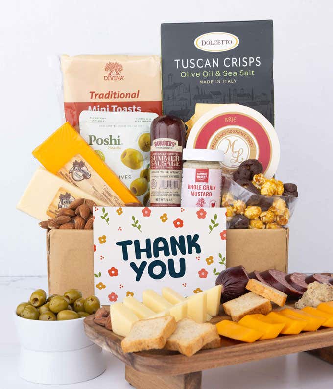 A gourmet charcuterie gift set featuring Tuscan crisps, focaccia crackers, 3 cheeses, olives, mustard, smoked almonds, chocolate-covered popcorn, sausage and finished with a Thank You card to show your appreciation.