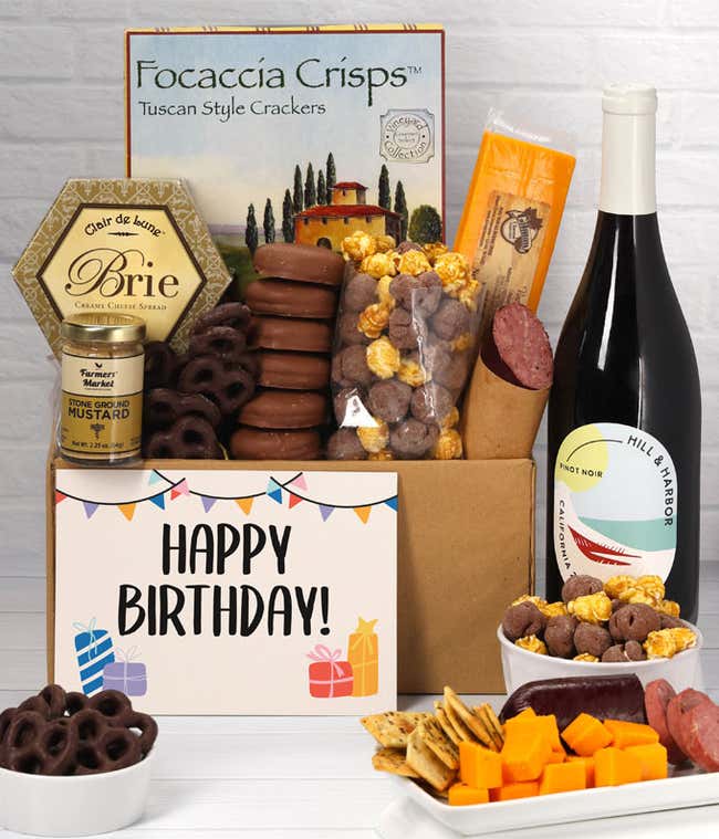 A gift set featuring a bottle of California Pinot Noir, focaccia crisps, two cheeses, mustard, summer sausage, caramel popcorn, chocolate pretzels, six chocolate-covered Oreos and a Birthday card to complete the gourmet experience.