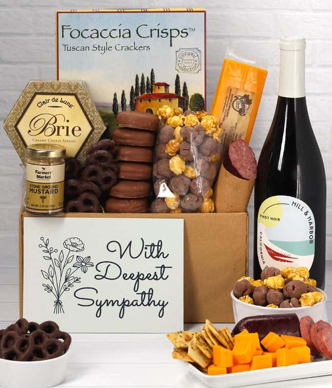 A gift set with a bottle of California Pinot Noir, focaccia crisps, two cheeses, mustard, summer sausage, caramel popcorn, chocolate pretzels, six chocolate-covered Oreos and a Sympathy card to show your support.