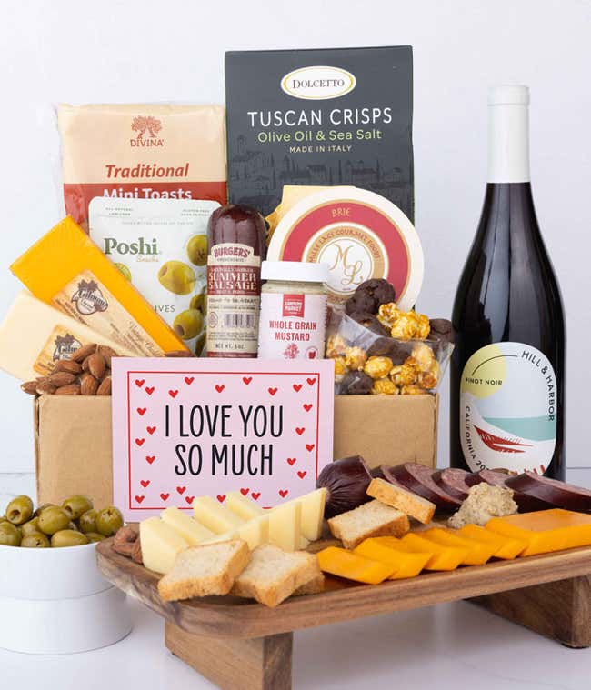 A luxurious gift box with two bottles of Hill &amp; Harbor wine (red &amp; white), three cheeses, gourmet crackers, summer sausage, marinated olives, smoked almonds, stone-ground mustard, chocolate-covered, and a pink 'I Love You So Much' card