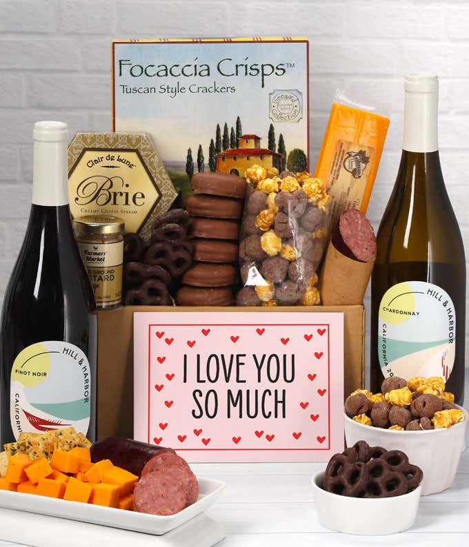 A gift featuring Hill & Harbor Pinot Noir, smoky sharp cheddar, Brie cheese spread, focaccia crisps, summer sausage, stone-ground mustard, chocolate-covered pretzels, chocolate-dipped cookies, caramel popcorn, and a romantic 'I Love You So Much' message.