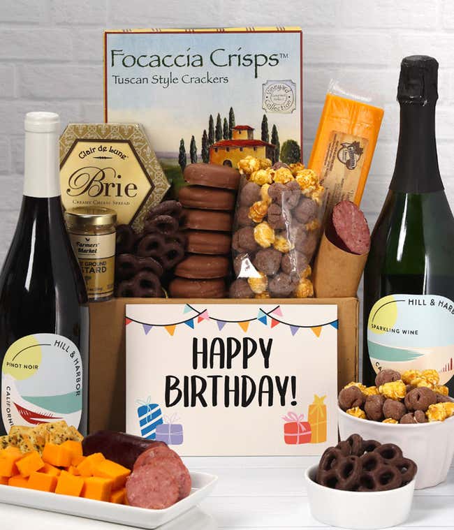 A gift set featuring 2 bottles of Hill &amp; Harbor wine - red and sparkling, focaccia crisps, two cheeses, mustard, summer sausage, caramel popcorn, chocolate pretzels, six chocolate-covered Oreos and a Birthday card to complete the gourmet experience.