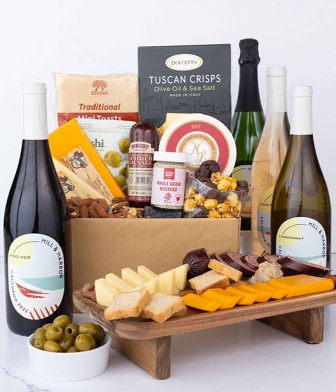 A wine and cheese gift set featuring 4 bottles of Hill & Harbor - Sparkling wine, Rosé wine, Chardonnay, and Pinot Noir. Includes a variety of cheeses, crackers, olives, smoked almonds, summer sausage, and condiments.